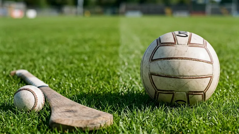 A hurley and sliotar beside a Gaelic football on the grass β the two GAA codes that bet very differently